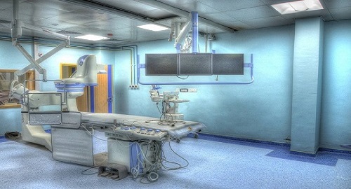 Operative responsible nurse anaesthetist preparing sterile surgical operation room for surgery with equipment, such as anesthesia machines